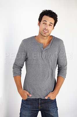 Buy stock photo Portrait of a handsome young man posing with his hands in his pockets against a wall
