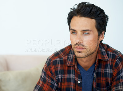 Buy stock photo Man, thinking and serious on sofa for idea, question and contemplating in living room of apartment or home. Person, face and thoughtful or calm by couch in lounge for chill, rest and shirt on weekend
