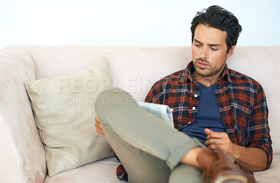 Buy stock photo Man, reading and relax with newspaper on couch in home, living room and learning about event or story in media. News, analysis and article in paper on sofa in morning at apartment with information