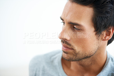 Buy stock photo Cropped shot of a handsome young man looking away thoughtfully