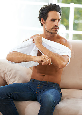 Buy stock photo Take off, tshirt and man on sofa in a house for comfort, rest or chilling on weekend, day off or vacation. Sweater, removal or male person in living room undressing, relax and ready to be comfortable