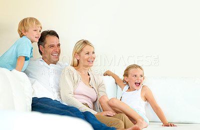 Buy stock photo Family, watching tv and happy on sofa with relax, peace and movie for bonding and relationship in living room. Parents, kids and face with smile of lounge with care, break and enjoyment in home