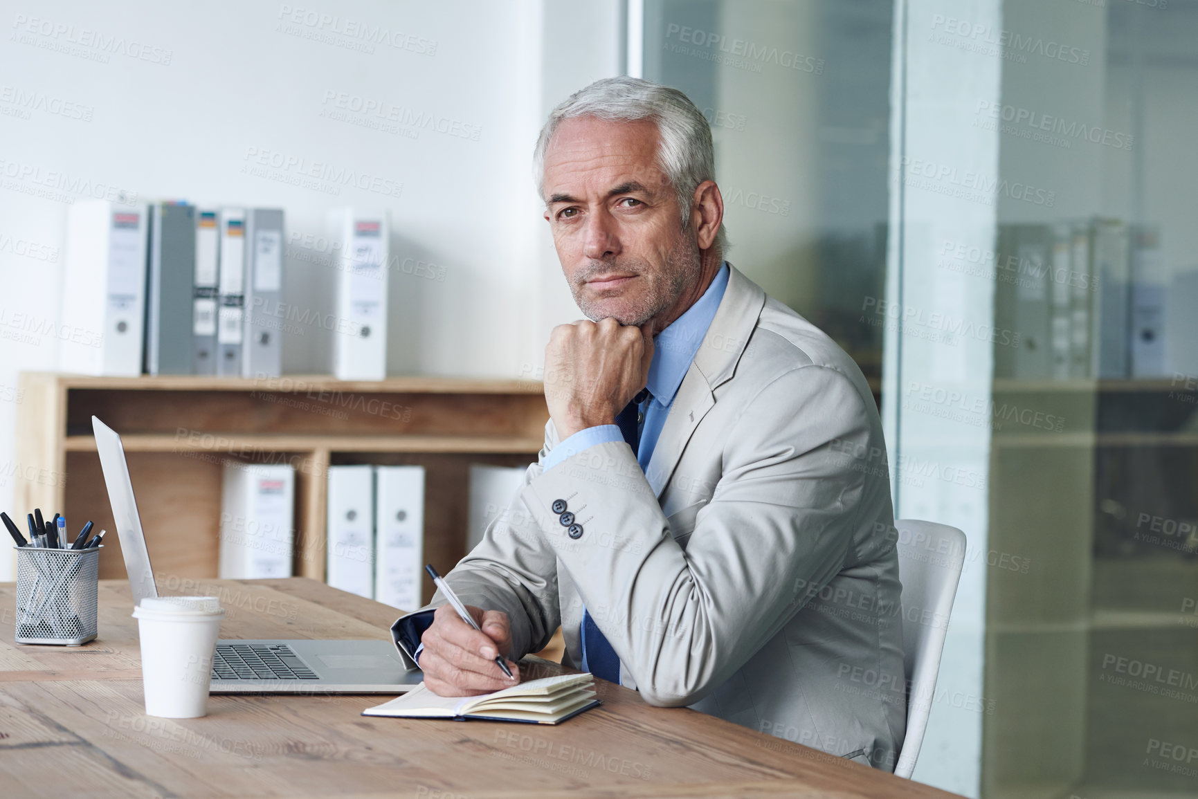 Buy stock photo Senior, businessman and writing, laptop and portrait at desk in the office for consultant notes. CEO, man and plan for budget, payroll and human resources for company in diary for startup proposal