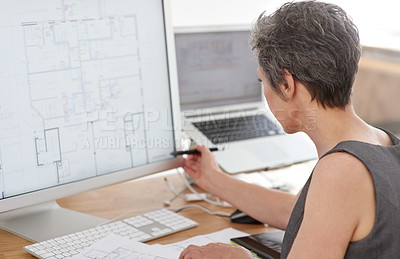 Buy stock photo A mature female architect working on building plans on her touchscreen computer