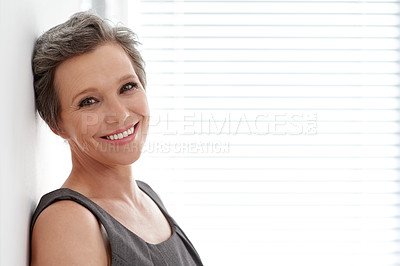 Buy stock photo Portrait of a mature businesswoman leaning against a wall in her office