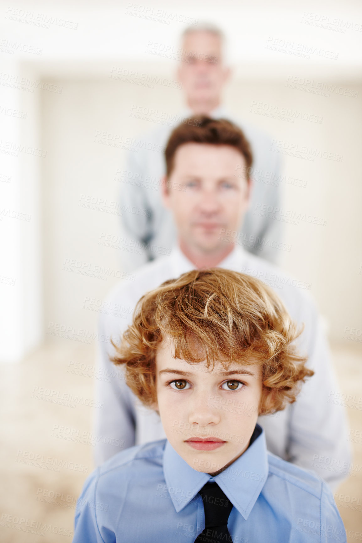 Buy stock photo Cropped portrait of a young boy standing with his father and grandfather