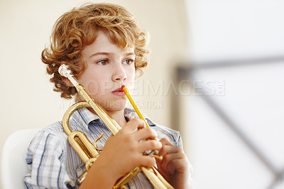 Buy stock photo Thinking, music and child with trumpet for practice, lesson and skills for talent show. Musician, creative hobby and young boy with musical instrument, paper and sheet notes to play song or melody