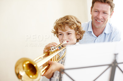 Buy stock photo Playing, music and father and child with trumpet for practice, lesson and skills for talent show. Family, creative hobby and dad with young boy with musical instrument, paper and notes to play song