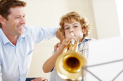 Buy stock photo Playing, music sheet and father and child with trumpet for practice, lesson and skills for talent show. Family, creative hobby and dad with young boy with instrument, paper and notes for song at home