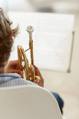 Buy stock photo Sheets, music and child with trumpet for learning, jazz lesson and practice for talent show. Musician, creative hobby and excited young boy with instrument, paper and home to play song or melody