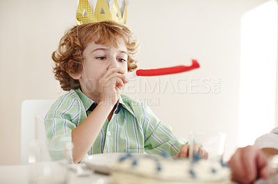 Buy stock photo Shot of a birthday boy blowing a party horn