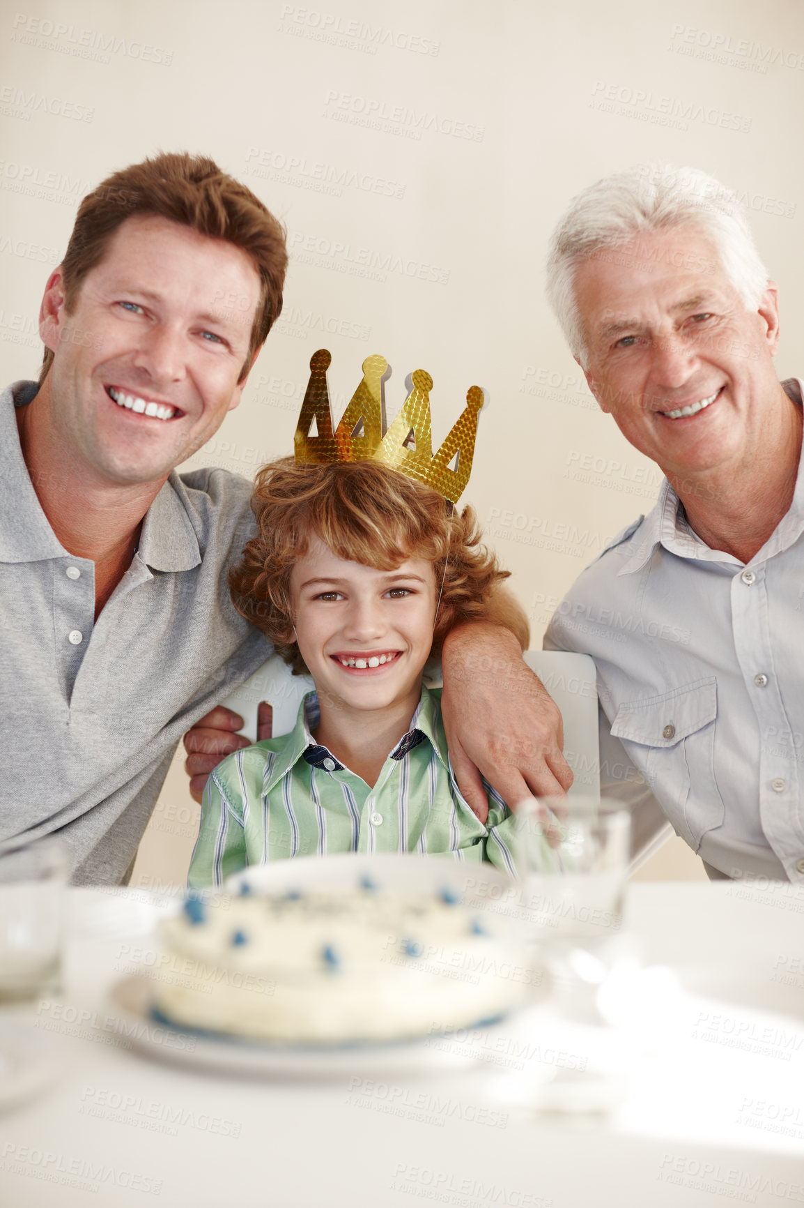 Buy stock photo Shot of a happy birthday boy sitting with his father and grandfather