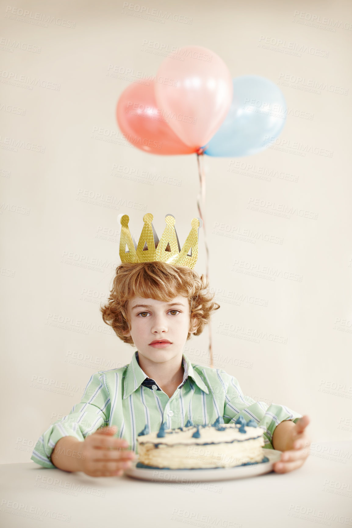 Buy stock photo Birthday cake, portrait and balloons with sad boy by table in family home for celebration, growth and lonely. Dessert, decoration and sweet pastry for event, serious and milestone with crown in house