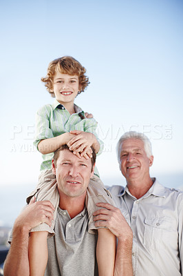 Buy stock photo Portrait of grandfather, father and child by ocean and blue sky for bonding, relationship and relax together. Family, fun and grandpa, dad and young boy on shoulders for holiday, vacation and weekend
