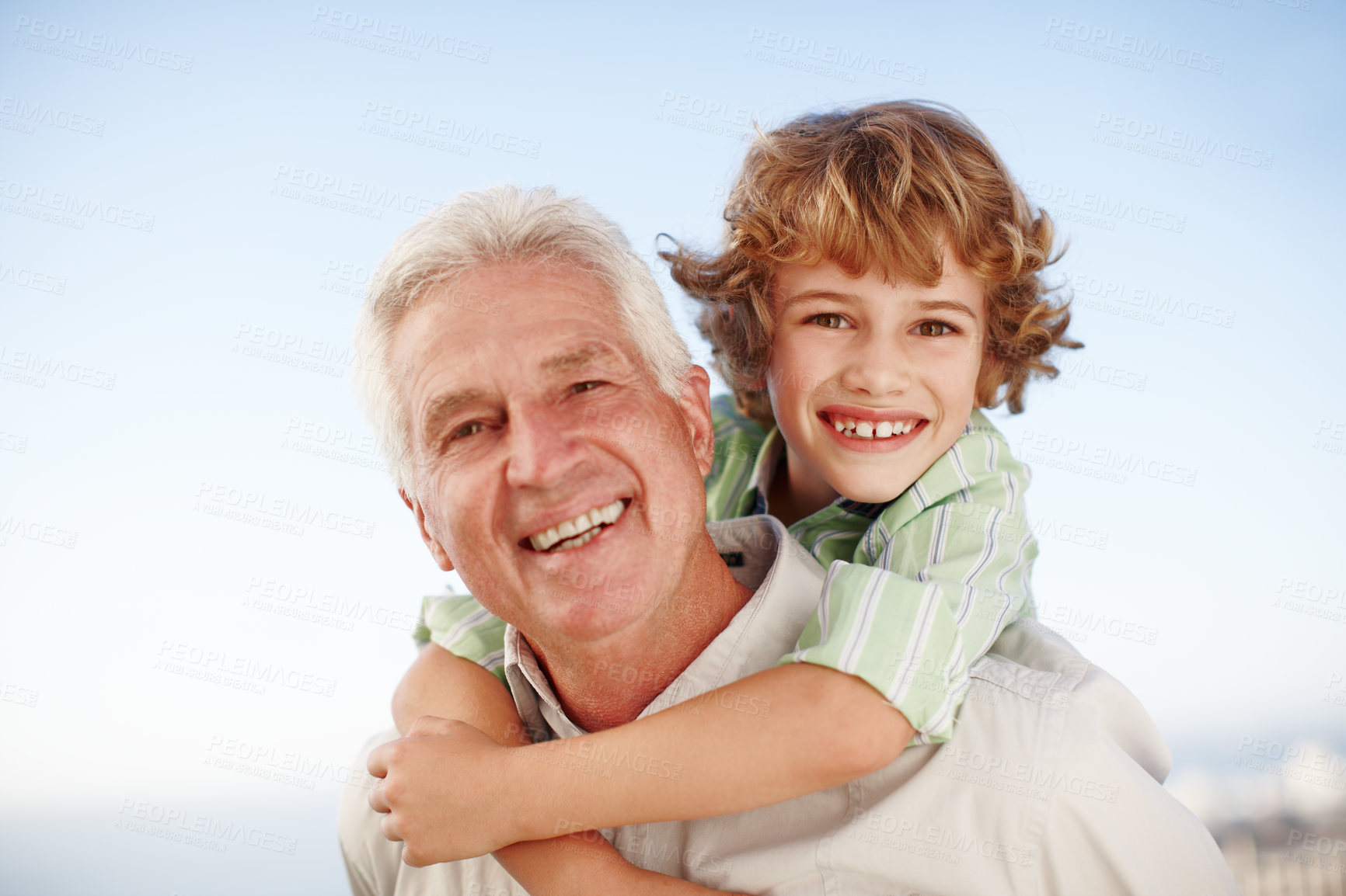 Buy stock photo Cropped portrait of a young boy getting piggybacked by his grandfather