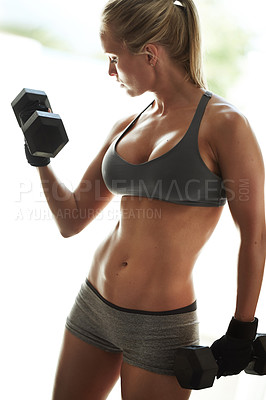 Buy stock photo Shot of a beautiful young woman in workout gear lifting dumbbells