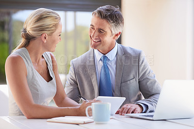 Buy stock photo Cropped shot of two colleagues working together at a desk