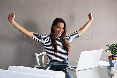 Buy stock photo Shot of an attractive young woman celebrating while working at her office desk