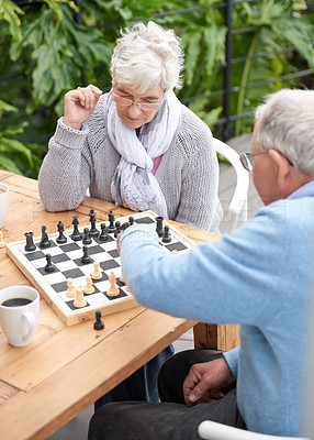 Buy stock photo Chess, strategy and senior couple thinking while playing a board game in the backyard or bonding together. Mind, relax or challenge with an elderly man or old woman in the garden for hobby and coffee