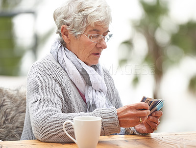 Buy stock photo Elderly woman, coffee and card games at table on bokeh background for retirement, old age and idea. Senior person or grandma with deck in hand for thinking, playing poker and relax or hobby outdoors 