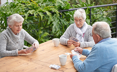 Buy stock photo Elderly people, card games and coffee at table with outdoor background for retirement and old age. Group, seniors or family with beverages and thinking for poker, relax and break together on patio