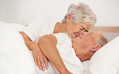 Buy stock photo Shot of a senior woman giving her husband a kiss in the morning