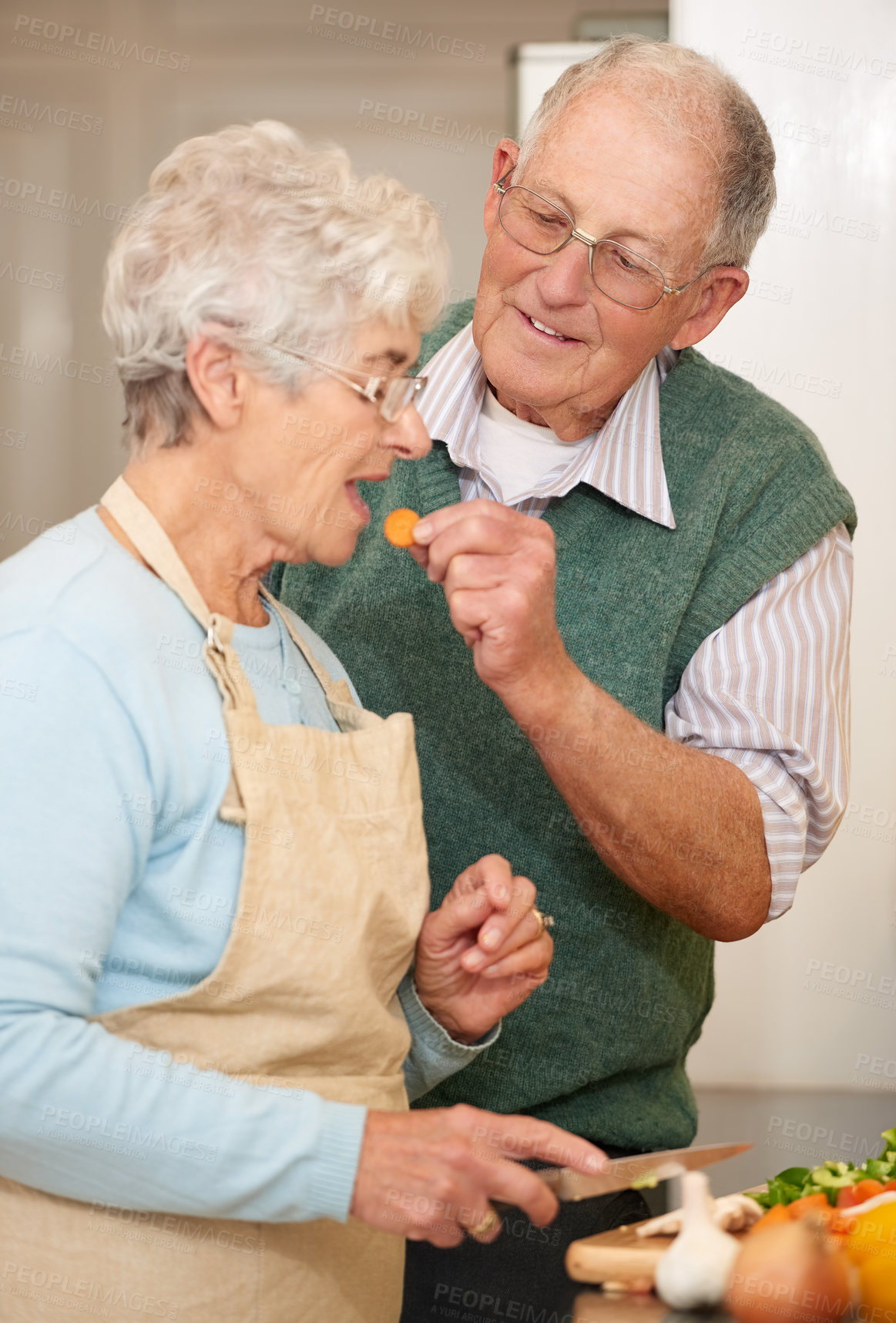 Buy stock photo Senior couple, cooking and taste in kitchen, food preparation and love at home. Elderly people, healthy meal and organic ingredients for nutrition, cutting vegetables and diet for detox in retirement