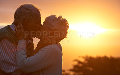 Buy stock photo Sunset, senior couple and kiss outdoor, care or bonding together for connection in marriage. Man, woman or touch lips for love, romance or embrace for commitment to relationship in retirement on date