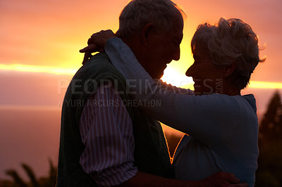 Buy stock photo Sunset, elderly couple and hug outdoor, love and bonding for connection together in nature. Man, woman and embrace for care, romance and support for commitment to relationship in retirement on date