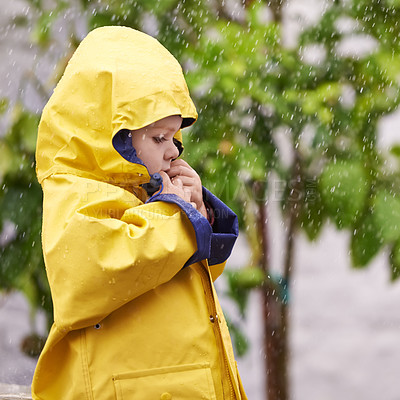 Buy stock photo Boy, nature and standing with jacket in rain for thinking, cold and sad on winter day in Australia. Young kid, childhood and development with pondering for gloomy, wet and lonely in rainy weather