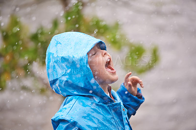 Buy stock photo Winter, raincoat and a girl having fun in the rain outdoor alone, playing during the cold season. Kids, water or wet weather with an adorable little female child standing arms outstretched outside