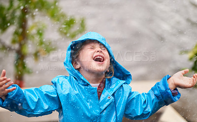 Buy stock photo Winter, rain jacket and a girl playing in the weather outdoor alone, having fun during the cold season. Children, water or wet with an adorable little female kid standing arms outstretched outside