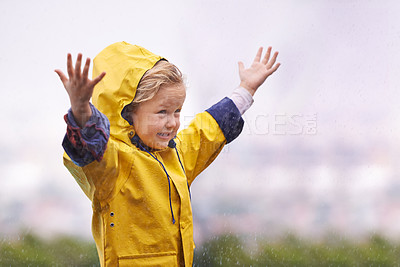 Buy stock photo Girl, outdoor and playing in rain with happiness, hands and freedom in backyard, park or garden. Young female child, open palm and excited face with raincoat, winter fashion and playful in raindrops