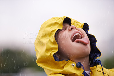 Buy stock photo Girl child, headshot and rain for playing, shouting and happiness in nature, outdoor and winter. Female kid, raincoat or playful with water, open mouth or taste on adventure with freedom in childhood