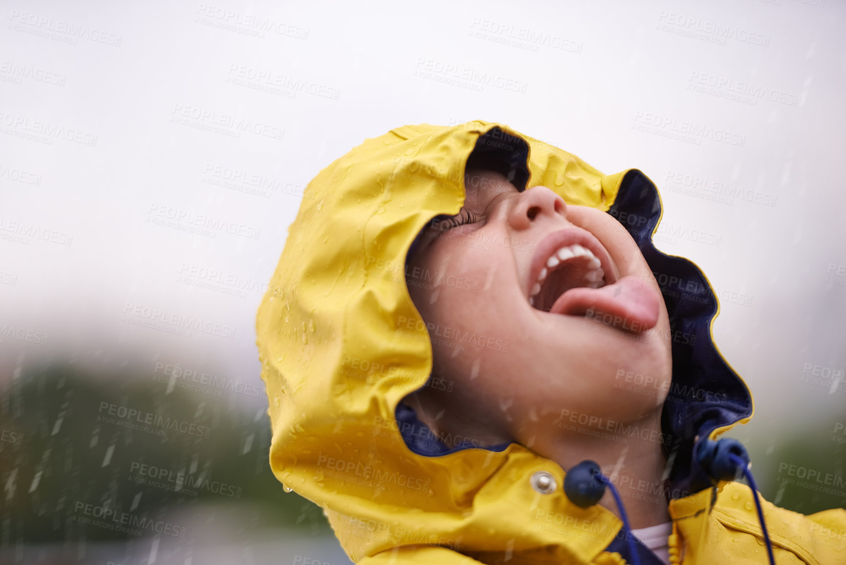 Buy stock photo Girl child, headshot and rain for playing, shouting and happiness in nature, outdoor and winter. Female kid, raincoat or playful with water, open mouth or taste on adventure with freedom in childhood