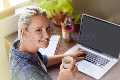 Buy stock photo Portrait of a young woman having coffee while working on her laptop at home