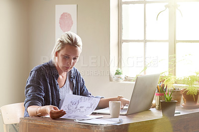 Buy stock photo Shot of a female graphic designer working on her laptop at home