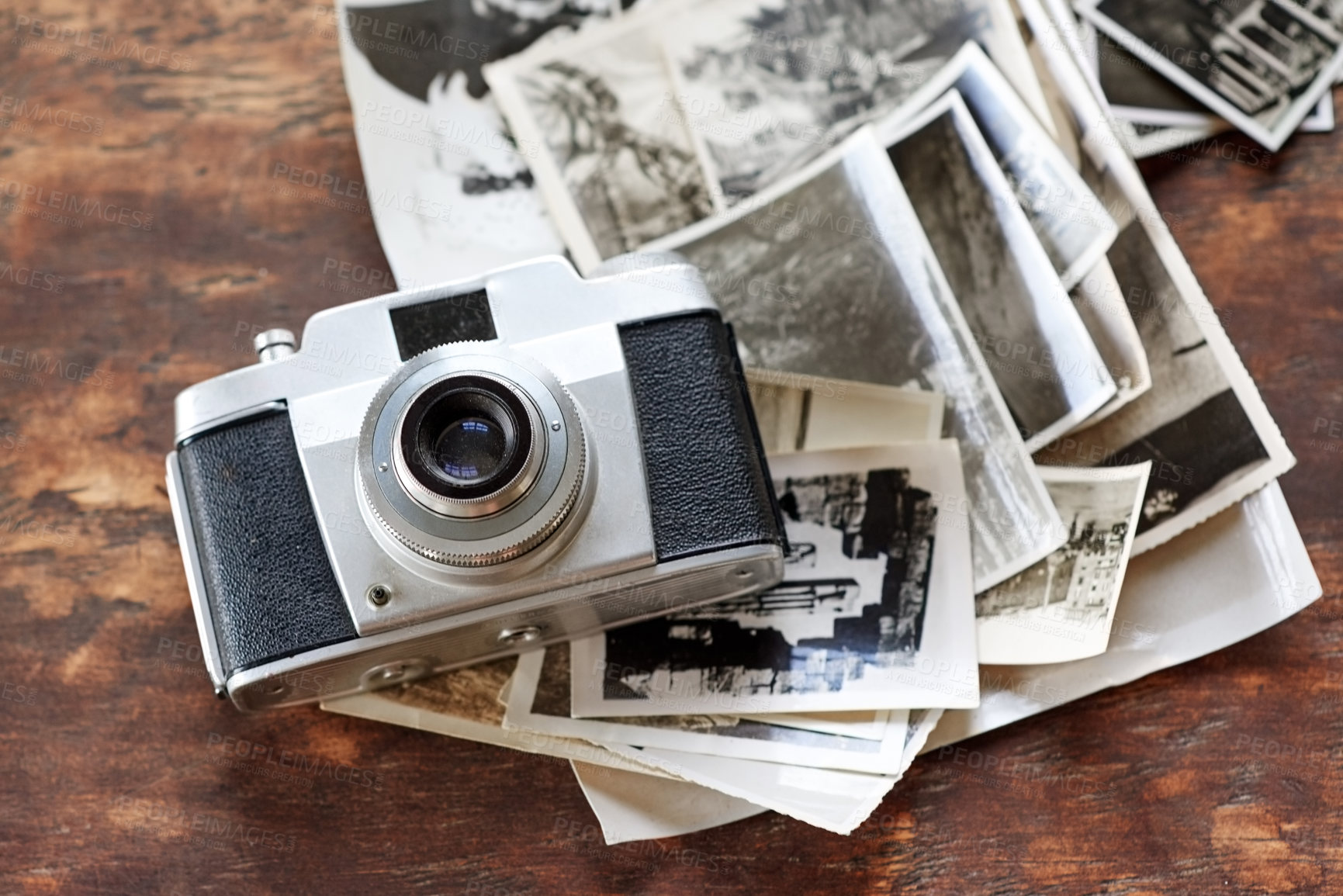 Buy stock photo Wooden table, vintage and camera with retro photographs on black and white. Digital, old school and desk with images for creativity, project and collection for filming, photoshoot and artistic
