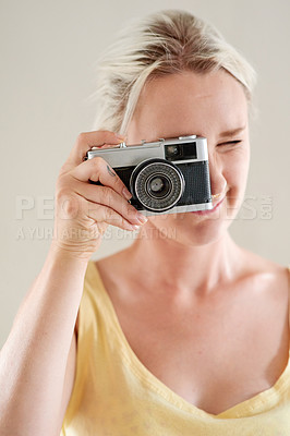 Buy stock photo Shot of a young woman taking a picture with an old-fashioned camera