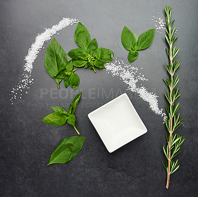 Buy stock photo Top view, herbs and salt isolated on black background for health, wellness and nutrition. Basil, rosemary and white bowl on dark surface in kitchen for cooking, plant and leaves on studio backdrop