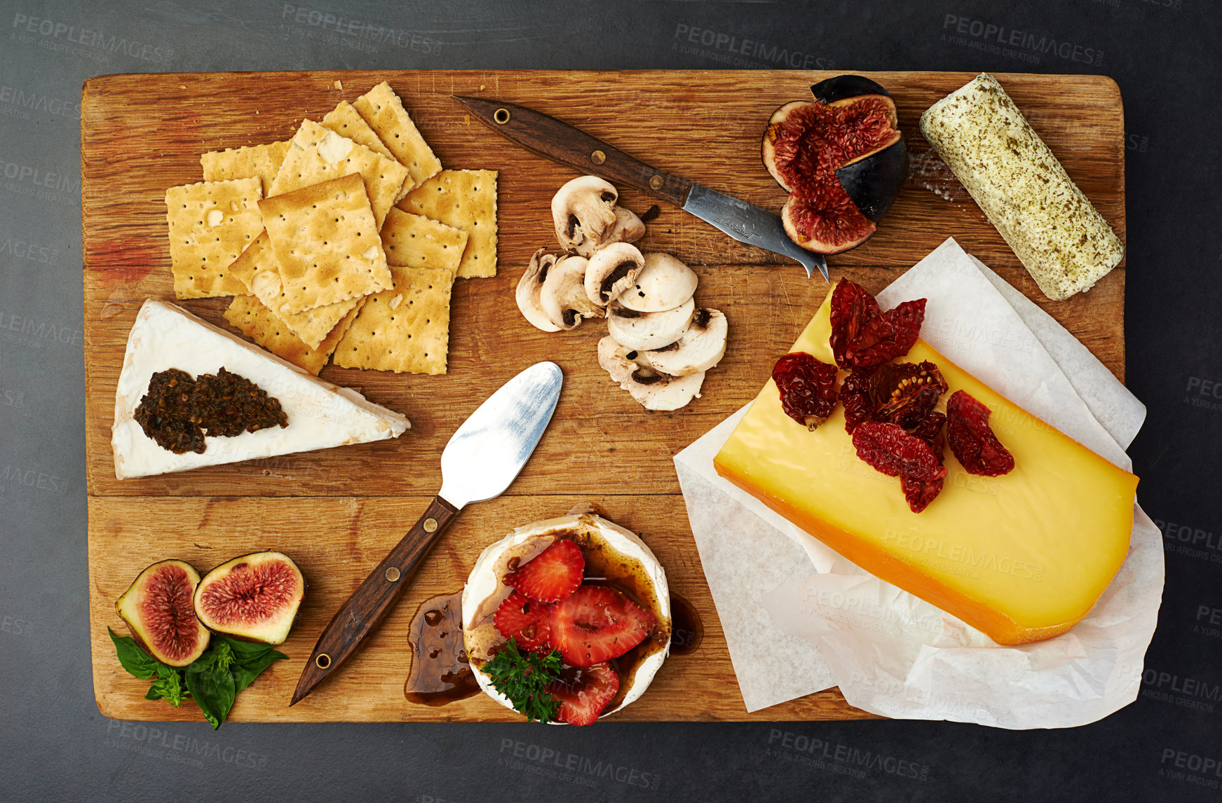 Buy stock photo Fruit, cheese and knife on wood table with appetizer, healthy eating and gourmet snack. Charcuterie board, nutrition and crackers on dark surface with lunch, mushrooms and fine dining for food choice