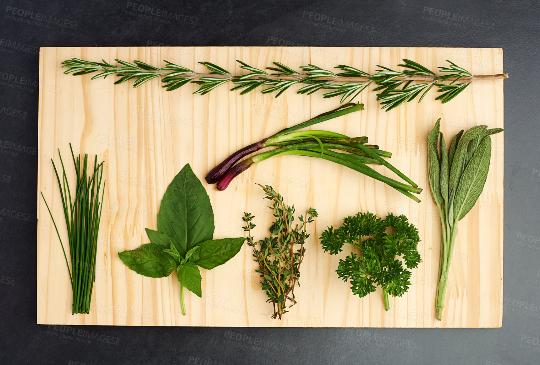 Buy stock photo Basil, thyme, and rosemary on chopping block for nutrition, health and adding flavour to food. Green herbs, parsley and vegetables on kitchen cutting board for cooking, eating and vegan diet
