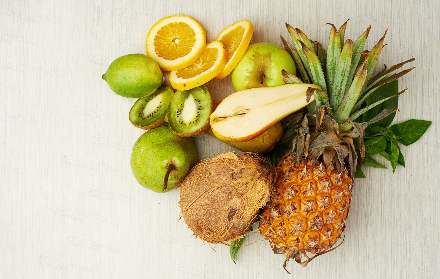 Buy stock photo Group, tropical and fruit on table for health, smoothie and vegan diet by light background with coconut. Pear, kiwi and vitamin c with nutrition on wood surface for weight loss, milkshake and energy