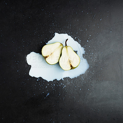 Buy stock photo Spill, cream and fruit by dark background for above with pear, smoothie and wellness. Dairy, fresh produce and liquid with protein on countertop for healthy diet, green and milk with weight loss