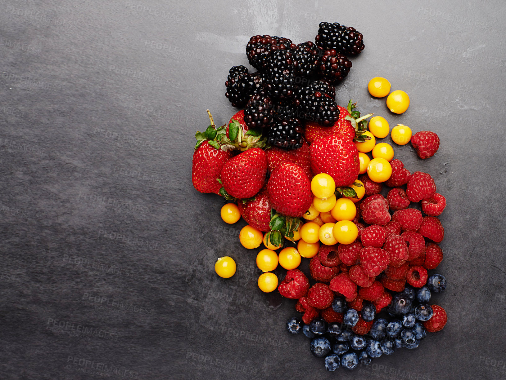 Buy stock photo Group, above and fruit by dark background for fresh, smoothie and vegan diet on table with strawberry. Blueberry, blackberry and detox with protein on grey surface for cocktail, milkshake and energy