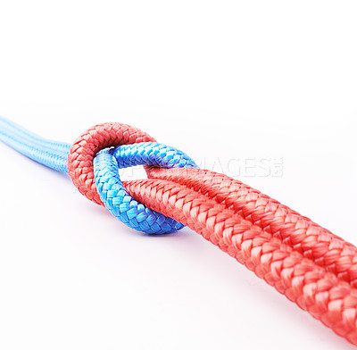 Buy stock photo Connected group, different ropes linked together as an unbreakable chain or community trust and faith metaphor and learning. Red and blue ropes in an overhand knot tied against a white background