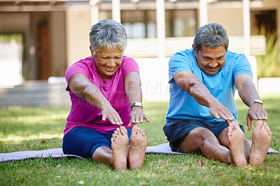 Buy stock photo Shot of a mature couple exercising together in their backyard