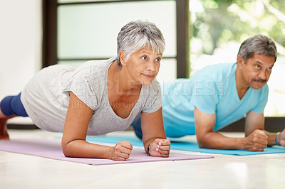 Buy stock photo Shot of a mature couple exercising together at home