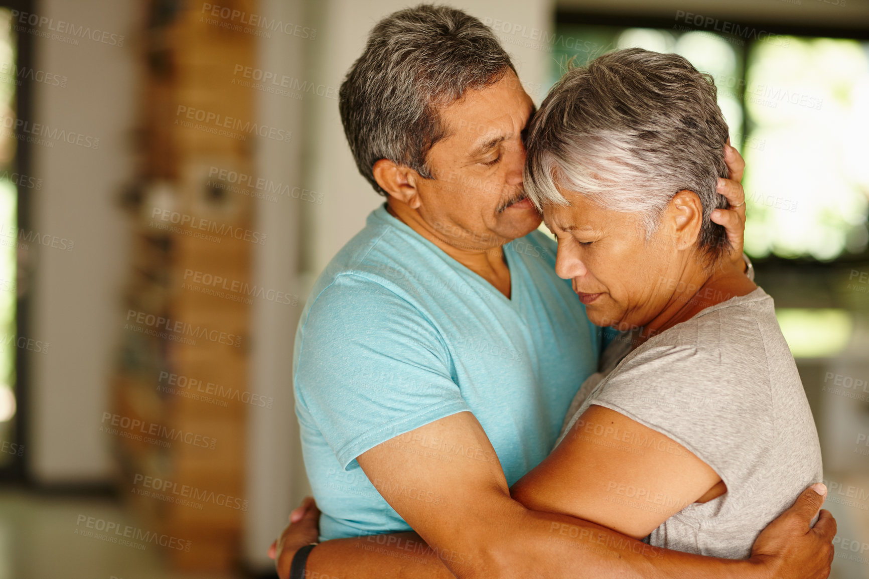 Buy stock photo Shot of a mature couple embracing at home