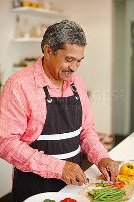 Buy stock photo Shot of a happy senior man cooking a healthy meal at home